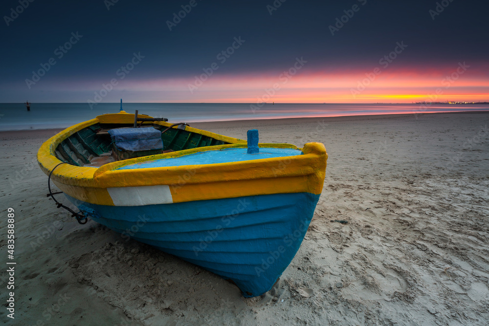 Fishing boat at sunrise on the Baltic Sea beach in Sopot. Poland Fishing boat at sunrise on the Baltic Sea beach in Sopot. Poland