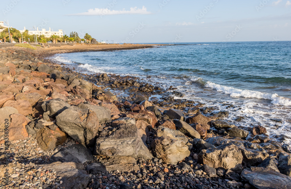 Volcanic beach with dark sand, rocks and sea on the background in Lanzarote, Canary Islands, Spain Volcanic beach with dark sand, rocks and sea on the background in Lanzarote, Canary Islands, Spain