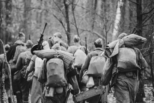 Re-enactors Dressed As World War II Russian Soviet Red Army Soldiers Marching Through Forest In Autumn Day. Photo In Black And White Colors. Soldier Of WWII WW2 Times.