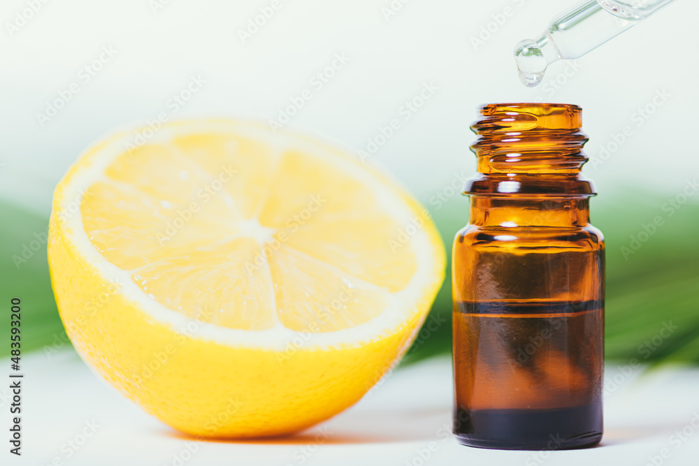 Lemon essential oil dripping into bottle with dropper Lemon essential oil dripping into bottle with dropper
