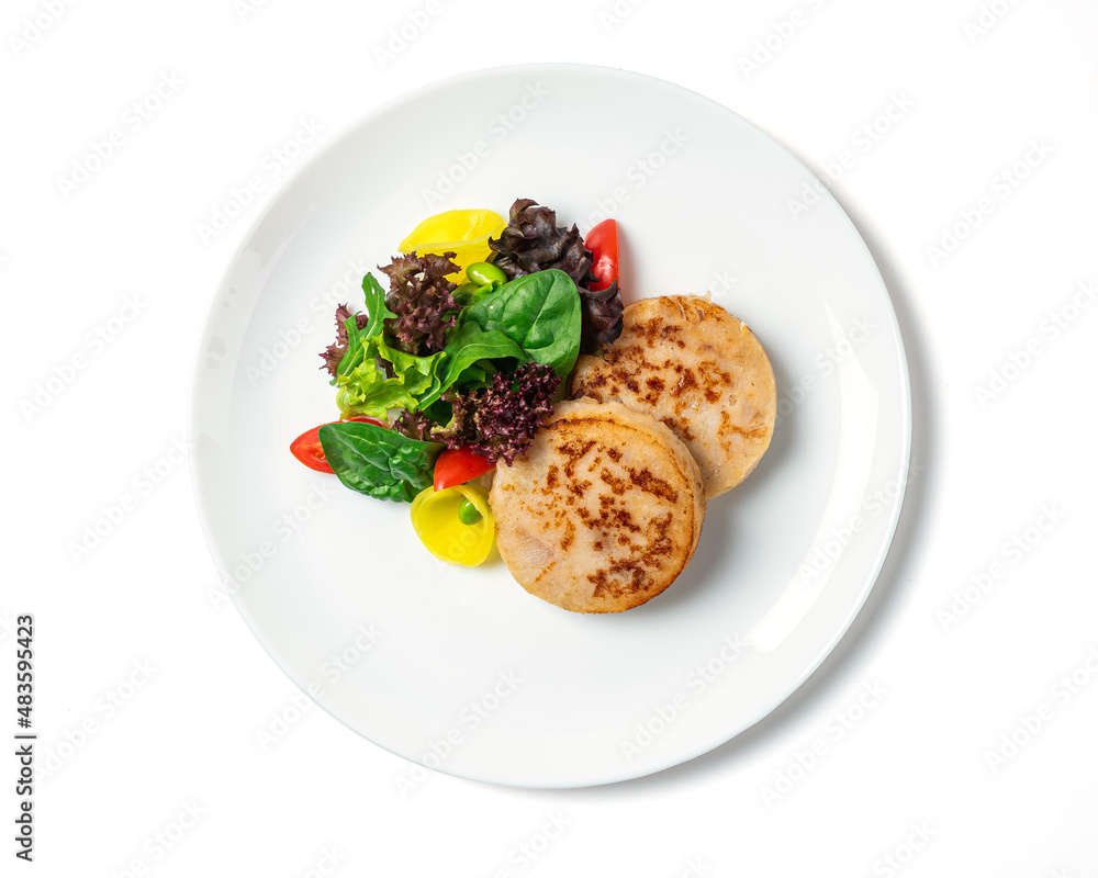 Fish cutlets with a vegetables served on the white plate isolated on white background. Top view Fish cutlets with a vegetables served on the white plate isolated on white background. Top view