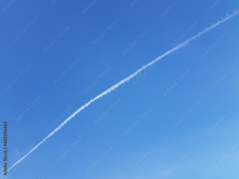 White trail of an airplane in the blue sky