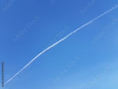 White trail of an airplane in the blue sky © kos1976
