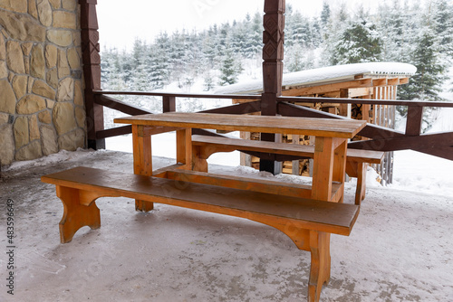 Gazebo with barbecue grill and barbecue, table and benches with fabulous views of the winter forest and mountains. Gazebo among the winter forest and mountains.