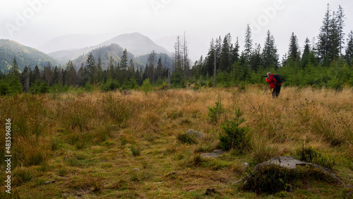 Man is taking photo in mountains.. Rainy day in Tatra Mountains, Poland, Europe.