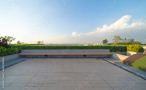 Fototapeta Naklejka Na Ścianę i Meble -  Sky garden on private rooftop of condominium or hotel, high rise architecture building with tree, grass field, and blue sky.