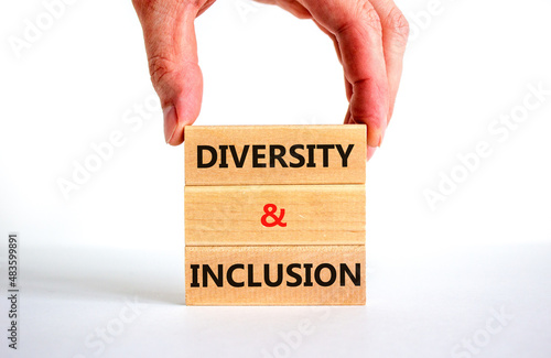 D and I, Diversity and inclusion symbol. Concept words D and I, diversity and inclusion on blocks on beautiful white background. Businessman hand. Business, D and I, diversity and inclusion concept. photo