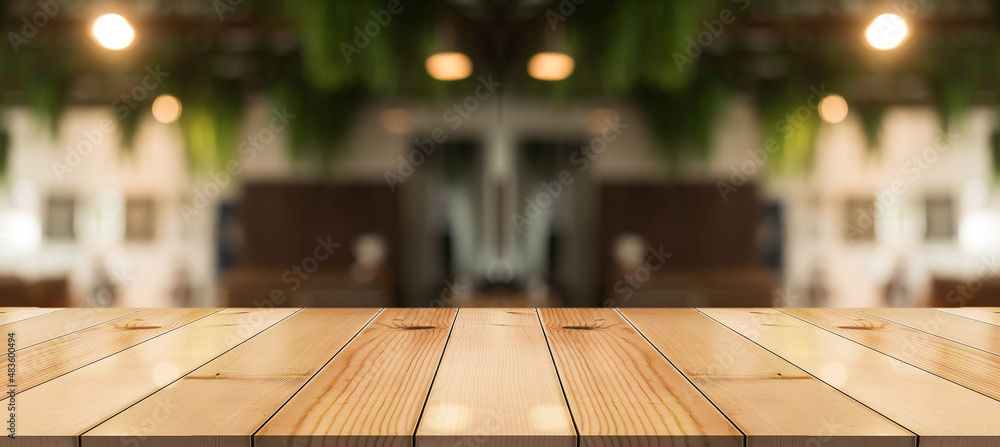 Empty wooden table top with lights bokeh on blur restaurant background. Empty wooden table top with lights bokeh on blur restaurant background.