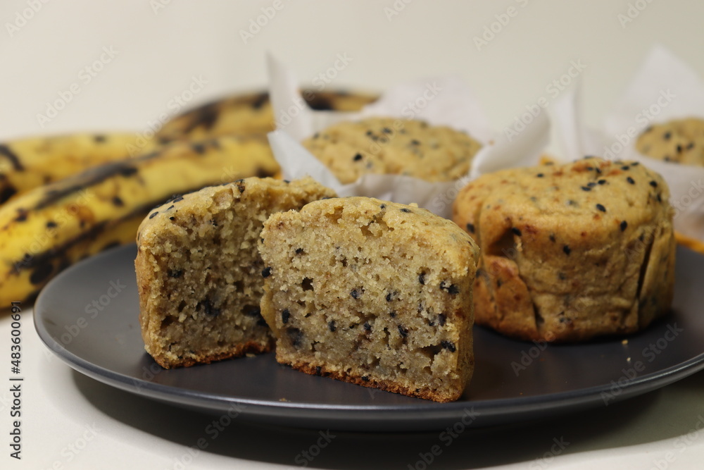 Plantain muffins. A healthy snack with extra ripe plantains, whole wheat flour and sesame seeds as the ingredients. Shot with muffins inside parchment paper cups