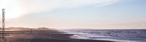Obraz na płótnie Wide panorama: people walking along the wide Blokhus Strand beach of North Sea. Evening landscape. Nordjylland (North Jutland Region), Denmark w salonie