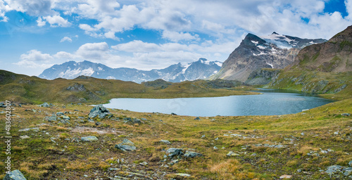 Idyllic blue alpine lake high up on the mountains, scenic landscape rocky terrain at high altitude on the Alps, panoramic view