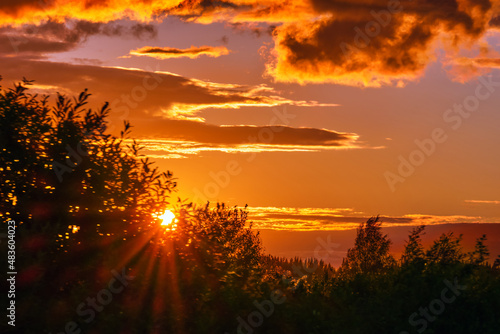 Sunset over the forest . Colorful evening sky over the trees . Bright sunlight .