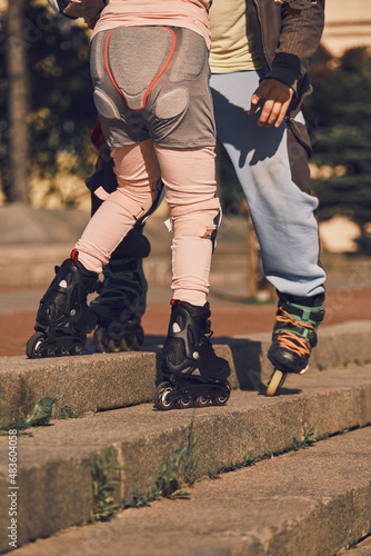 The father teaches the child to go down the stairs on roller skates. Overcoming obstacles.