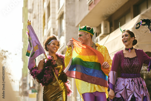 Group of cheerful friends celebrating Mardi Gras and have fun on street parade during the festival.