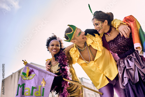 Fotografiet Happy multiracial friends in carnival costumes have fun on Mardi Gras celebration parade