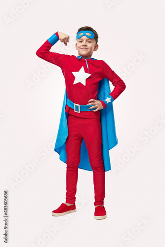 Strong superhero boy showing muscles