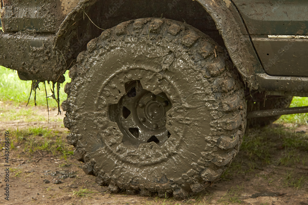 Dirty offroader wheel is standing on the road with the ground. Jeep after an off-road trip. Dirty offroader wheel is standing on the road with the ground. Jeep after an off-road trip.