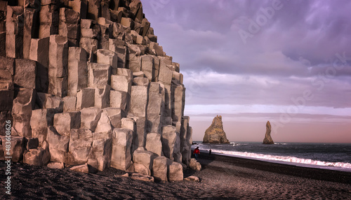 Amazing nature landscape of Iceland. View on big octagonal basalt  boulders on black sand beach and picturesque rocks in the sea in background.  Vic, Iceland, Cape Dyrholaey viewpoint. photo
