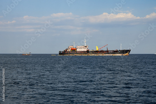 Large vessel carries goods and other cargo, it has a lifting crane and antennas for communication.