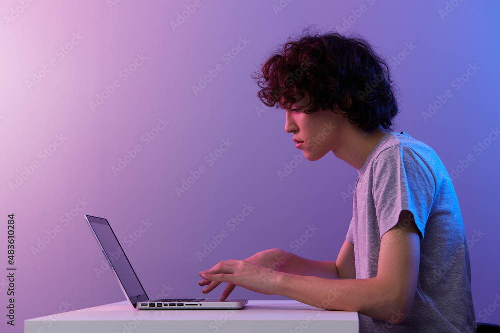 Naklejka premium man cyberspace playing with in front of a laptop violet background