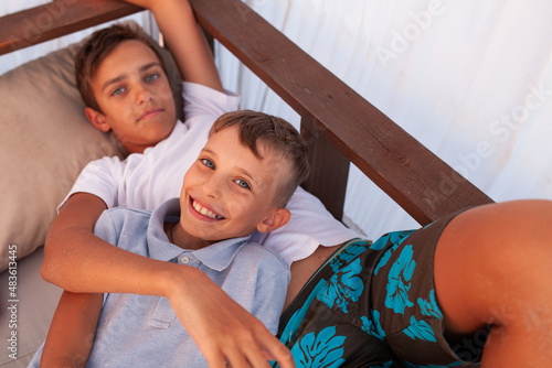 Fotografía The brothers lie on a wooden bed in a bungalow near the sea.