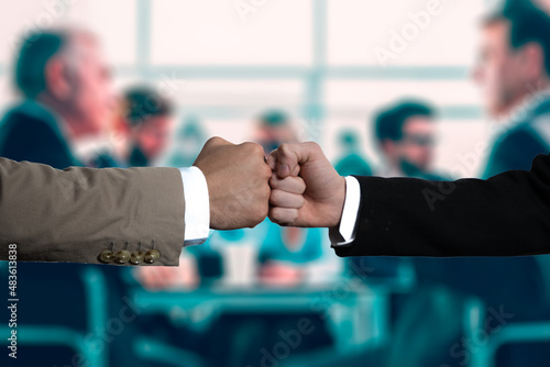 Businessmen shaking hands in the office with computer