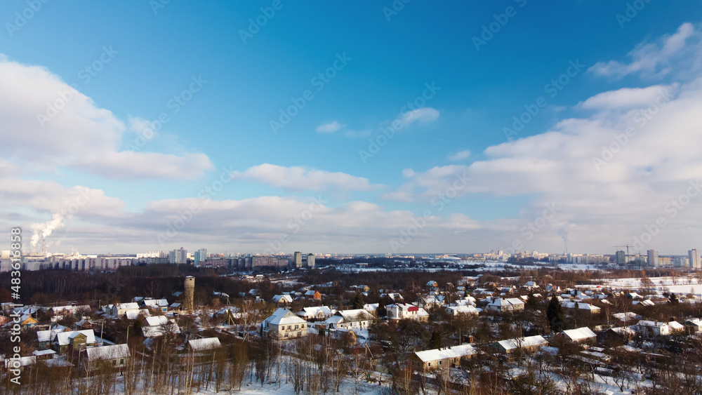 Obraz premium Low-rise urban development. The ground and buildings are covered with snow. Winter cityscape. Aerial photography.