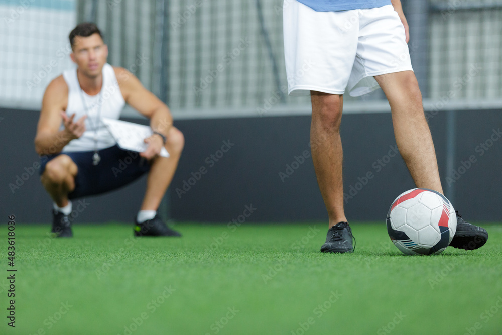 coach and man playing football indoor