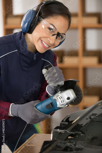 female worker using angle grinder