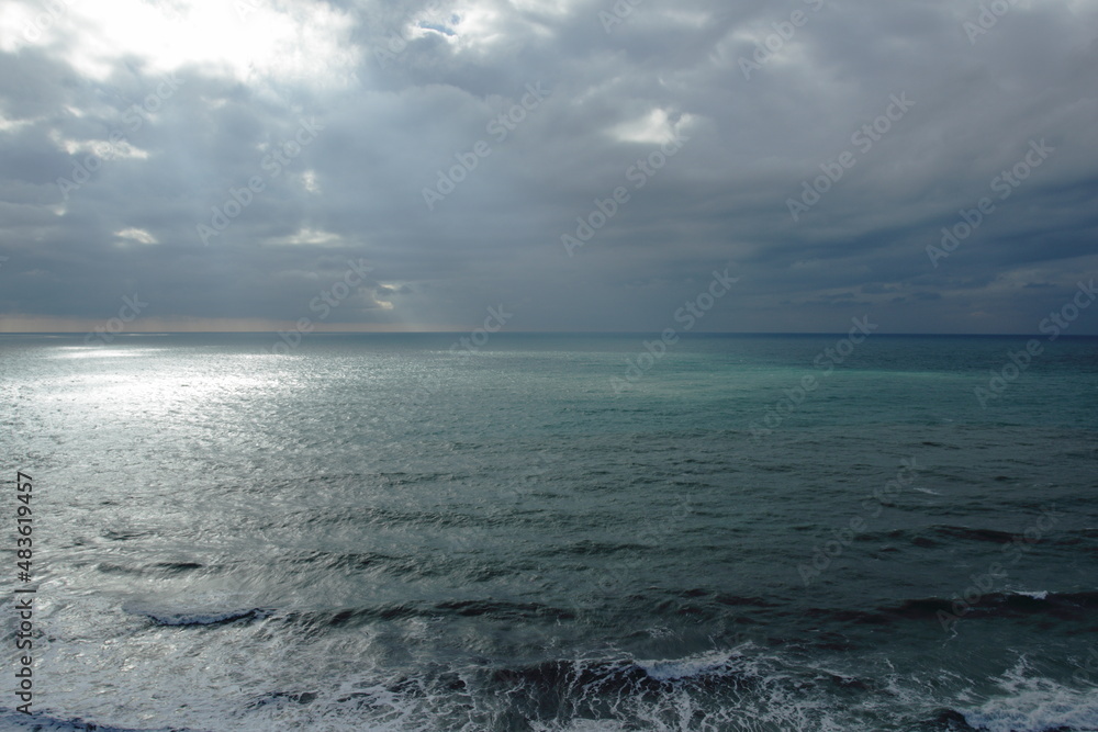 seascape winter sea on the background of clouds illuminated by sunlight