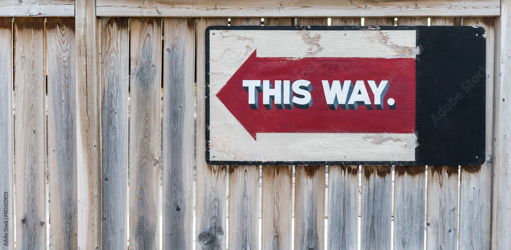 This way red arrow sign on wooden fence background Stock Photo | Adobe