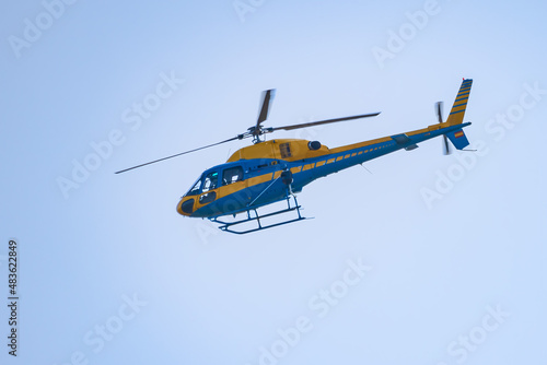 Yellow and blue Helicopter of Traffic surveillance Patrolling the roads and highways to control reckless driving.