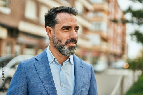 Middle age businessman smiling happy standing at the city.