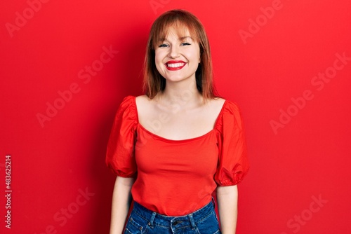 Redhead young woman wearing casual red t shirt with a happy and cool smile on face. lucky person.