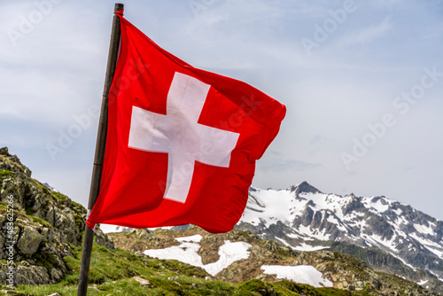 swiss flag in the snowy alps mountains - selective focus. photo