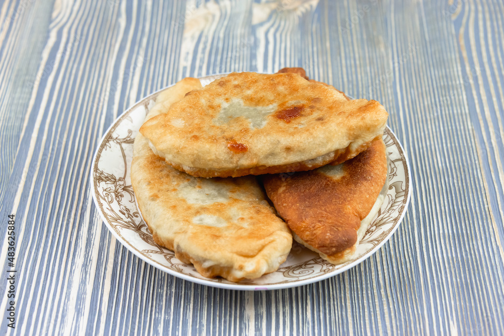 Fried pies with potatoes on a plate.