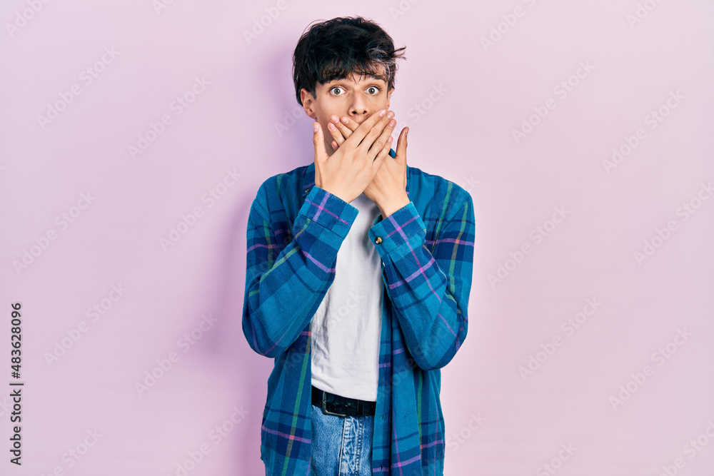 Handsome hipster young man wearing casual white t shirt and vintage shirt shocked covering mouth with hands for mistake. secret concept. Handsome hipster young man wearing casual white t shirt and vintage shirt shocked covering mouth with hands for mistake. secret concept.