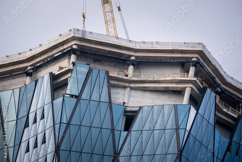 construction of skyscrapers and cranes, office buildings with glass facades, selective focus photo