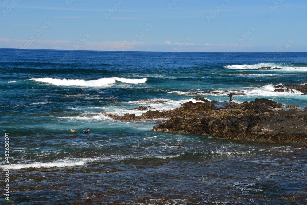 SURFERO EN UNA COSTA ROCOSA