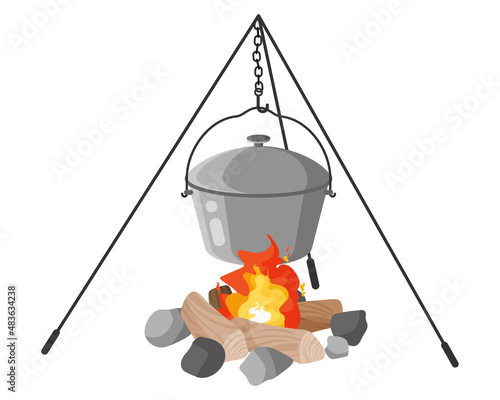 Military soldier metal camping pot or mess kit on fire with tripod for cooking. Touristic equipment for camping.
