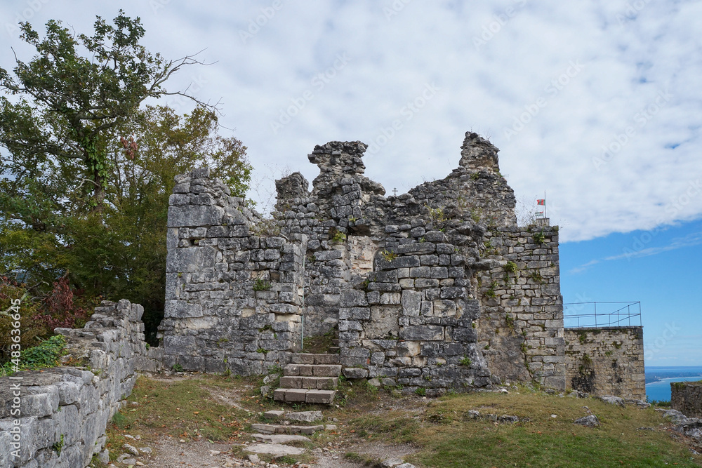 Ruins of ancient Anacopia Fortress at the top of the Iverian Mountain.  Old military citadel in New Athos, Abkhazia. Sunny summer day, cloudy sky. Popular tourist destination in Novy Afon