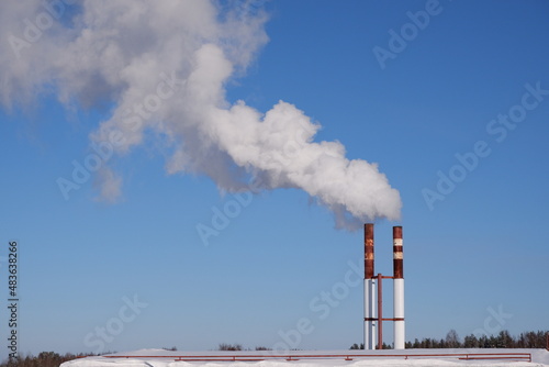 White smoke against the blue sky.Puffs of white smoke from the chimney