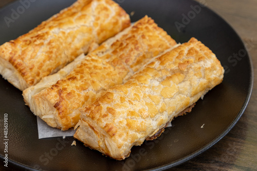 Baked puff pastry with toppings on a black plate