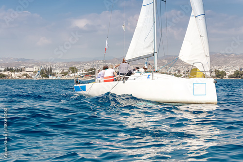 Unrecognizable athletes team on a sailing yacht during regatta competition