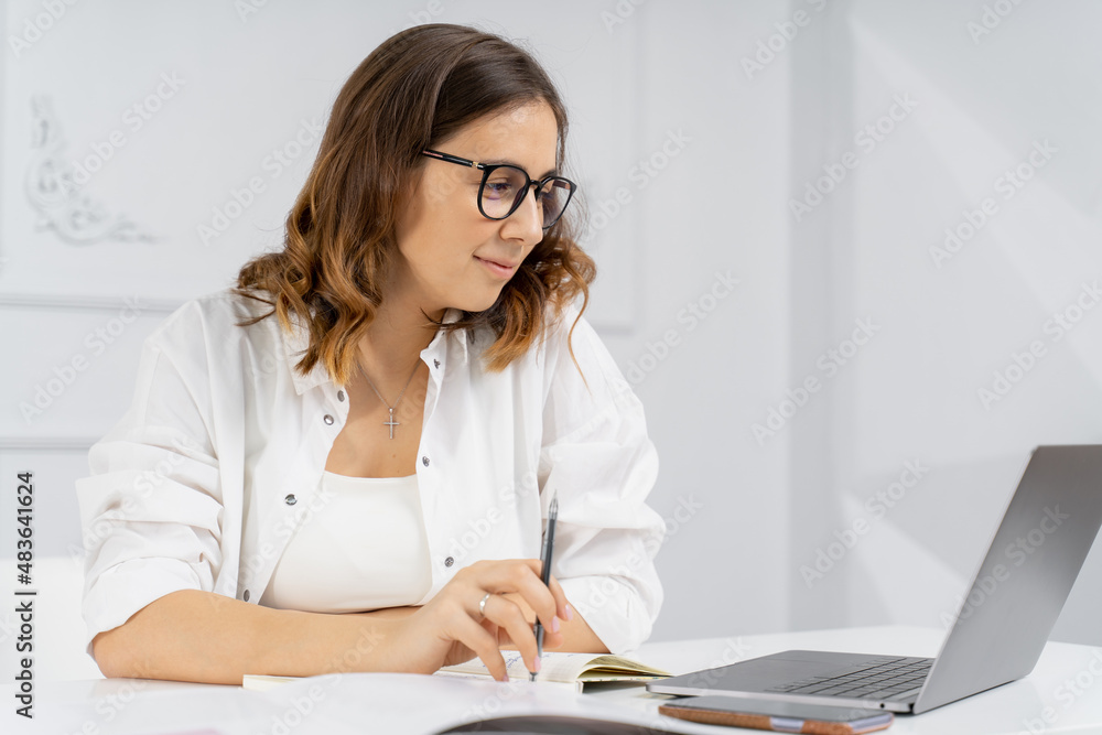 Pretty young beautiful woman sitting holding a pen Pretty young beautiful woman sitting holding a pen