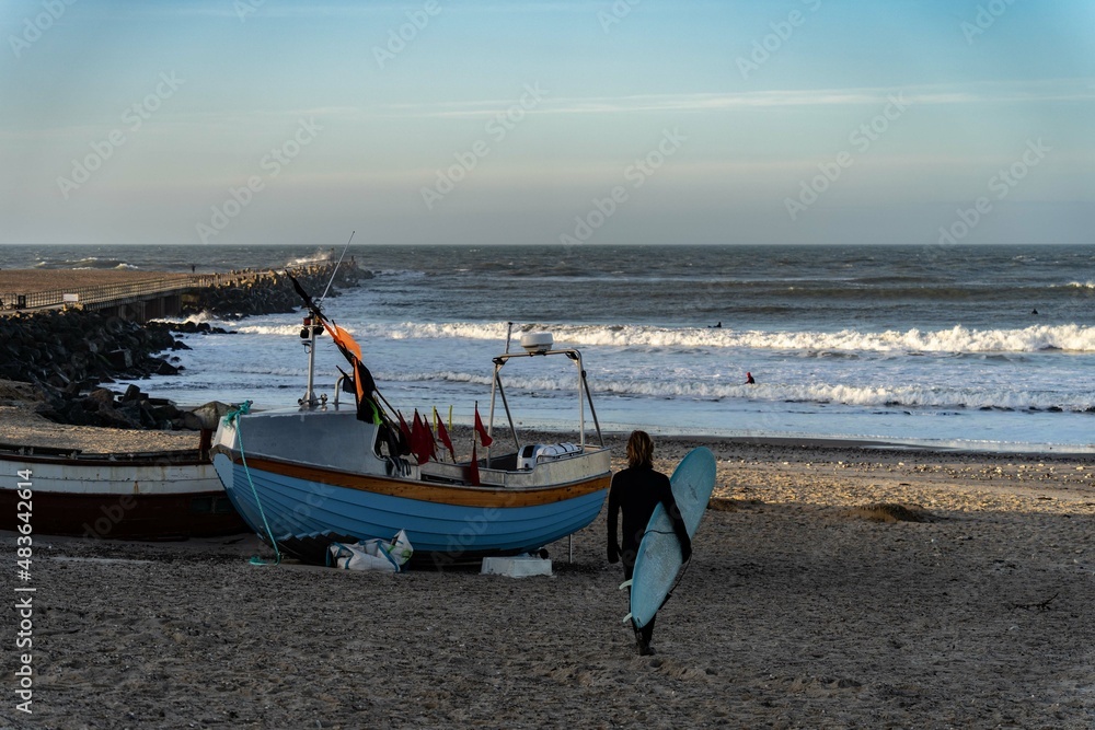 Surfer wait to catching waves in cold water in winter, cold hawaii, norre vorupor, Klitmoller and Hanstholm, denmark