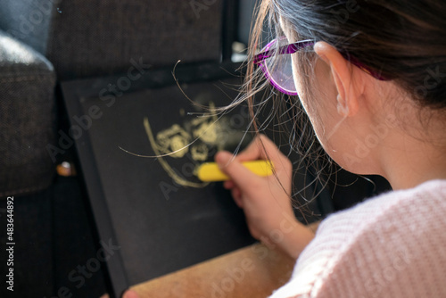 child drawing figgures on blackboard