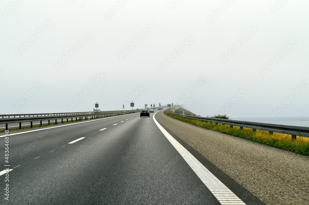 Fototapeta premium The Oresund bridge over the sea connecting Sweden and Denmark is lost in the fog