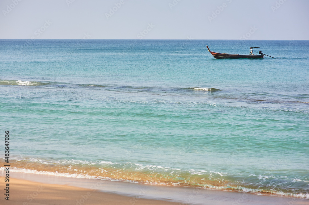 Travel by Thailand. Sea beach with traditional longtail boat.