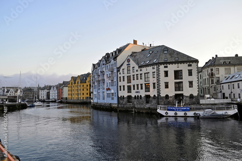 Alesund, Norway - 05 July 2011: Old colorful houses on the waterfront in Alesund, Norway in the evening at sunset.